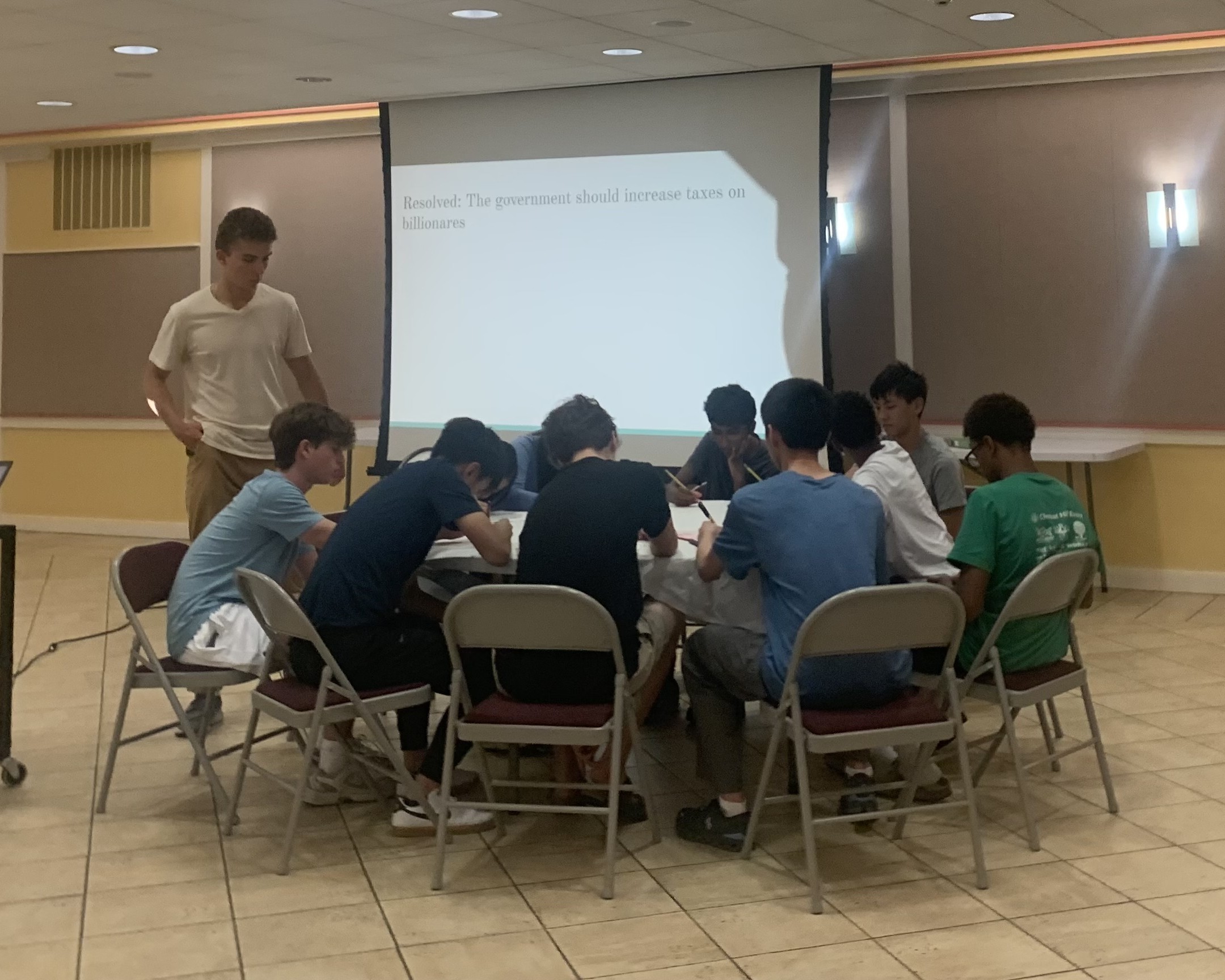 Students gathered around a table during a debate exercise